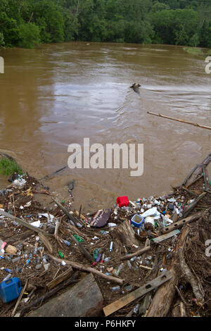 Tutti i tipi di umana prodotta dai detriti, come bottiglie di plastica e rami, legno e fango intasare e inquinare un fiume dopo un allagamento Foto Stock