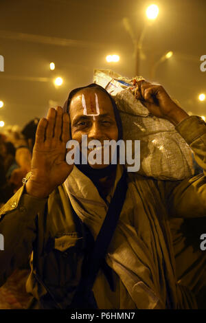 Ritratto di uomo pellegrino in mezzo alla folla la sacca di custodia durante il Maha Kumbh Mela 2013 in Allahabad , India Foto Stock