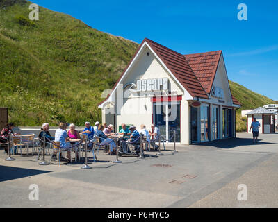 Oscar pesce e Chip Shop sul lungomare a Saltburn North Yorkshire affollate di persone che godono di cibo fuori in sumer sun Foto Stock