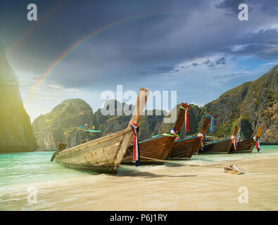 Maya Bay sull'isola di Phi Phi in estate una giornata soleggiata con golden sabbia di corallo, rocce, barca in primo piano e mare turchese. Krabi - Thailandia Foto Stock