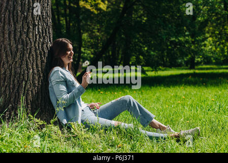 Bella giovane donna con il bianco tarassaco in posizione di parcheggio Foto Stock