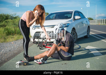 Asia ciclista feriti sulla street bike dopo incidente auto e moto. Foto Stock