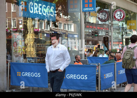 La gente a piedi passato una fila di caffetterie e take-away a negozi di alimentari compresi tostiera e panificio Greggs, e Mikel Coffee Company su Tottenham Court Road Foto Stock