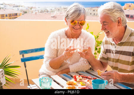 Bella coppia di pensionati soggiorno adulti insieme sul roofto pterrace bere e mangiare un po' di cibo e bevanda. sorriso persone all'aperto in grande lifesty Foto Stock