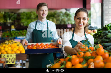 Sorridente roba russa nel grembiule vendita di arance dolci, limoni e mandarini Foto Stock