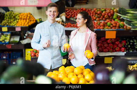 Positivi i giovani clienti acquisto di arance, limoni e mandarini nella sezione di negozi di generi alimentari Foto Stock