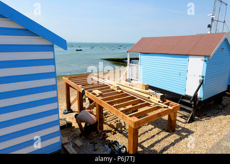 Operai della costruzione di un nuovo beach hut in una fila di capanne a Thorpe Bay, Southend on Sea, Essex, Regno Unito. Foto Stock