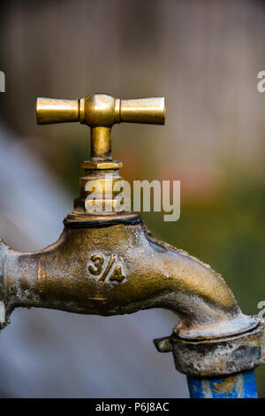 Vecchio e usato Vintage rubinetto isolato.Profilo di bronzo rubinetto metallico,blu con un tubo bianco alla fine e il numero 3/4 su un lato e DF su altri. Foto Stock