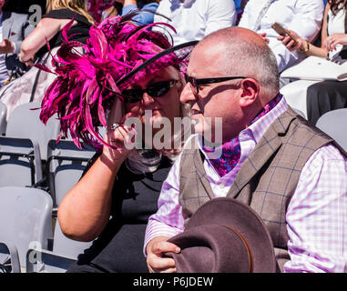 Una femmina di razza goer indossando una grande rosa cappello piumato e suo compagno di indossare tuta con gilet, York, Inghilterra, 30 giugno 2018. Foto Stock