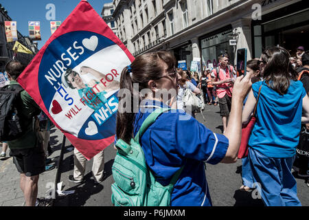 Una donna con un poster di infermieri del NHS. Decine di migliaia di persone hanno marciato durante il caldo sabato meteo attraverso Londra per celebrare e dimostrare in Gran Bretagna il servizio sanitario nazionale (NHS), prima del suo settantesimo compleanno la prossima settimana. Foto Stock