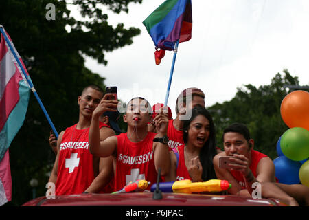 Orgoglio marzo i partecipanti tenendo bandiere. Migliaia di gay i membri hanno marciato per le strade di Marikina, Metro Manila come essi hanno partecipato a questo anno di orgoglio marzo. Foto Stock