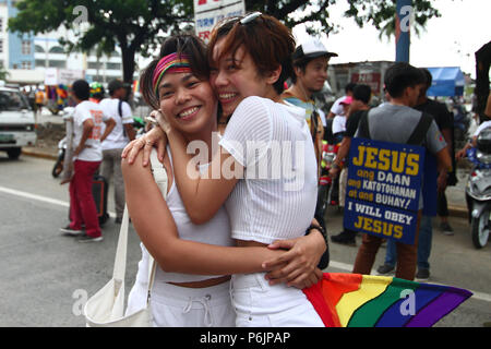 Un paio di abbracci e sorrisi durante l'orgoglio di marzo. Migliaia di gay i membri hanno marciato per le strade di Marikina, Metro Manila come essi hanno partecipato a questo anno di orgoglio marzo. Foto Stock