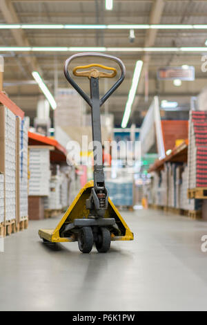 Martinetto pallet in un edificio store. Manuale martinetto pallet nel supermercato. Foto Stock