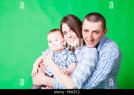 Giovani ritratto di famiglia su un verde b Foto Stock