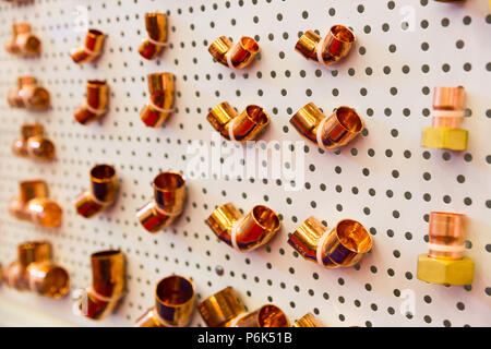 I raccordi di saldatura di rame Tubo di acqua, attrezzature idrauliche sul supporto in negozio. Ingegneria sanitaria, pipeline in metallo Utensili di installazione Foto Stock