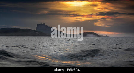 Il castello di Bamburgh visto dal mare a farne le isole. Northumberland Coast, Inghilterra, Europa Foto Stock