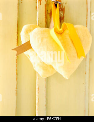 Close-up di cuore giallo a forma di sacchetti di lavanda appeso sulla maniglia per porta Foto Stock