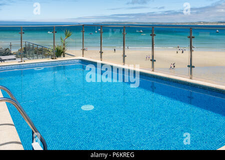 ST IVES, Inghilterra - 18 giugno: un vibrante blu hotel piscina sul bordo della spiaggia di Porthminster. In St Ives, Cornwall, Inghilterra. Il 18 giugno 2018. Foto Stock