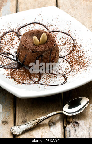 Dolce al cioccolato torta decorata con lo sciroppo al cioccolato mandorle e cacao in polvere Foto Stock