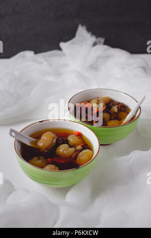 Red Data Longan zuppa. Dessert cinese nella ciotola verde. Due ciotole. Foto Stock