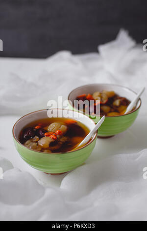 Red Data Longan zuppa. Dessert cinese nella ciotola verde. Due ciotole. Foto Stock