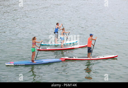 Paddle boarders godetevi il clima mite nel mare di Bournemouth Dorset, come il clima caldo continua in tutto il paese. Foto Stock