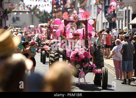 Il convoglio di trattori fare il suo modo attraverso Harleston in Norfolk durante la quindicesima signore in rosa su strada del trattore correre in aiuto del Cancer Research UK. Foto Stock