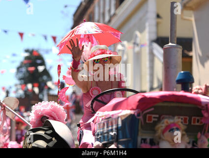 Il convoglio di trattori fare il suo modo attraverso Harleston in Norfolk durante la quindicesima signore in rosa su strada del trattore correre in aiuto del Cancer Research UK. Foto Stock