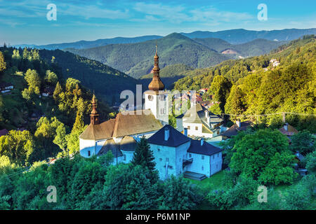 Il vecchio villaggio minerario. Chiesa Storica in Spania dolina. Alberi Falltime all'alba,Slovacchia Foto Stock