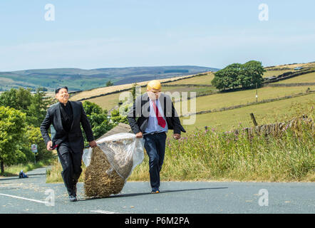 I concorrenti prende parte sulla paglia Oxenhope gara nello Yorkshire, a 2,5 miglia gara in costume , portando un 20kg balle di paglia, mentre l'arresto per pinte di birra lungo il percorso. Foto Stock