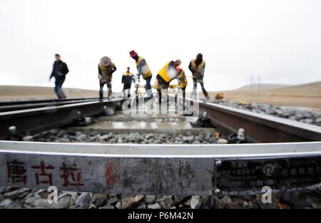 Golmud, la Cina della Provincia di Qinghai. Il 30 giugno, 2018. Lavoratori rafforzare le vie sotto la pioggia vicino la stazione di Tanggula della ferrovia Qinghai-Tibet, a nord-ovest della Cina di Provincia di Qinghai, 30 giugno 2018. Lavoratori di manutenzione stick per i loro posti ogni giorno per garantire il funzionamento della ferrovia Qinghai-Tibet presso la stazione di Tanggula con un altitudine di 5,072 metri sopra il livello del mare. Il 1,956 chilometri di ferrovia, che ha iniziato il servizio nel luglio 2006, è la più alta del mondo altopiano di collegamento ferroviario Xining in Qinghai e Lhasa nella regione autonoma del Tibet. Credito: Hou Deqiang/Xinhua/Alamy Live News Foto Stock