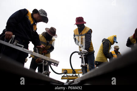 Golmud, la Cina della Provincia di Qinghai. Il 30 giugno, 2018. Lavoratori rafforzare le vie sotto la pioggia vicino la stazione di Tanggula della ferrovia Qinghai-Tibet, a nord-ovest della Cina di Provincia di Qinghai, 30 giugno 2018. Lavoratori di manutenzione stick per i loro posti ogni giorno per garantire il funzionamento della ferrovia Qinghai-Tibet presso la stazione di Tanggula con un altitudine di 5,072 metri sopra il livello del mare. Il 1,956 chilometri di ferrovia, che ha iniziato il servizio nel luglio 2006, è la più alta del mondo altopiano di collegamento ferroviario Xining in Qinghai e Lhasa nella regione autonoma del Tibet. Credito: Zhang Hongxiang/Xinhua/Alamy Live News Foto Stock