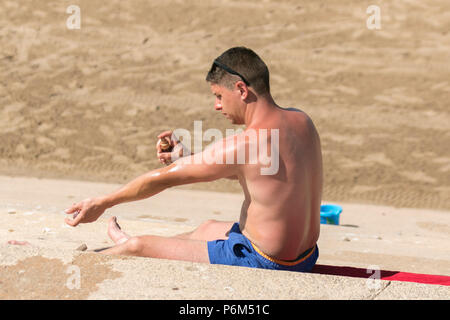 Blackpool, Lancashire, 1 lug 2018. Regno Unito: Meteo Sunny torrida giornata presso la costa come per i fanatici del sole godetevi incantesimo sulla spiaggia prima di essere inseguita dalla marea. Credito: MediaWorldImages/AlamyLiveNews Foto Stock