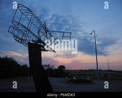 Eastchurch, UK. 1 Luglio, 2018. Regno Unito Meteo: il tramonto dietro la bi-piano scultura in Eastchurch, Kent. Eastchurch villaggio sull'Isle of Sheppey celebrato cento anni di storia dell'aviazione nel luglio del 2009, che la scultura è stata installata per commemorare i. Il primo volo controllato da un pilota britannico sul suolo britannico ha avuto luogo all'estremità orientale dell'isola di Sheppey, che è conosciuto come il luogo di nascita di aviazione britannica. Credito: James Bell/Alamy Live News Foto Stock