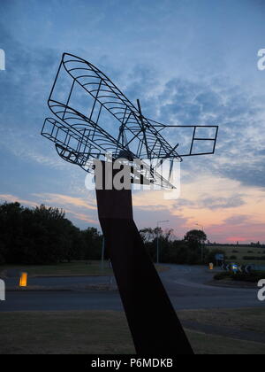 Eastchurch, UK. 1 Luglio, 2018. Regno Unito Meteo: il tramonto dietro la bi-piano scultura in Eastchurch, Kent. Eastchurch villaggio sull'Isle of Sheppey celebrato cento anni di storia dell'aviazione nel luglio del 2009, che la scultura è stata installata per commemorare i. Il primo volo controllato da un pilota britannico sul suolo britannico ha avuto luogo all'estremità orientale dell'isola di Sheppey, che è conosciuto come il luogo di nascita di aviazione britannica. Credito: James Bell/Alamy Live News Foto Stock