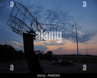 Eastchurch, UK. 1 Luglio, 2018. Regno Unito Meteo: il tramonto dietro la bi-piano scultura in Eastchurch, Kent. Eastchurch villaggio sull'Isle of Sheppey celebrato cento anni di storia dell'aviazione nel luglio del 2009, che la scultura è stata installata per commemorare i. Il primo volo controllato da un pilota britannico sul suolo britannico ha avuto luogo all'estremità orientale dell'isola di Sheppey, che è conosciuto come il luogo di nascita di aviazione britannica. Credito: James Bell/Alamy Live News Foto Stock