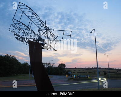 Eastchurch, UK. 1 Luglio, 2018. Regno Unito Meteo: il tramonto dietro la bi-piano scultura in Eastchurch, Kent. Eastchurch villaggio sull'Isle of Sheppey celebrato cento anni di storia dell'aviazione nel luglio del 2009, che la scultura è stata installata per commemorare i. Il primo volo controllato da un pilota britannico sul suolo britannico ha avuto luogo all'estremità orientale dell'isola di Sheppey, che è conosciuto come il luogo di nascita di aviazione britannica. Credito: James Bell/Alamy Live News Foto Stock
