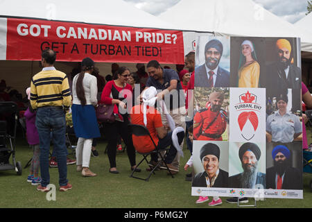 Calgary, Canada. 1 Luglio, 2018. L'uomo diventa turbante legato al turbante, eh?, un evento ospitato dal Mondo Organizzazione Sikh al principe Island Park sul Canada il giorno. Le persone sono state invitate ad avere un colore rosso o bianco turbante avvolto attorno alla loro testa e conoscere la cultura Sikh. Rosanne Tackaberry/Alamy Live News Foto Stock