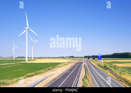 Le turbine eoliche sono situati in un terreno coltivabile verde accanto a un'autostrada a Terneuzen Zeeland Paesi Bassi Foto Stock