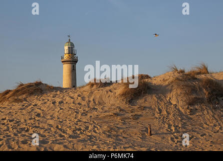 Warnemuende, faro dietro una duna di sabbia al mattino Foto Stock