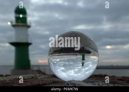 Warnemünde, fari al molo sono riflesse nel crepuscolo in una sfera di vetro Foto Stock