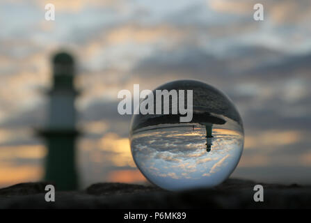 Warnemünde, fari al molo sono riflesse nel crepuscolo in una sfera di vetro Foto Stock