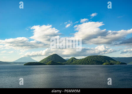 Isola di Nakajima e il Monte Yotei erano visti dalla riva del Lago Toya dopo una piovosa giornata nuvolosa nel mese di giugno, 2018. Foto Stock