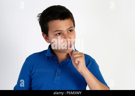 12-anno-vecchio ragazzo spazzolando i suoi denti. Foto Stock