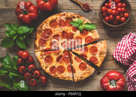 In casa salsiccia per pizza pizza su una vecchia tavola in legno rustico. Vista superiore, tonica immagine Foto Stock