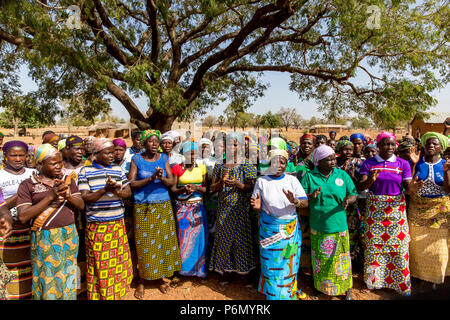 I membri di una donna cooperativa di microfinanza accogliente un visitatore nel nord del Togo. Foto Stock