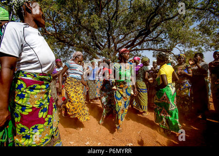 I membri di una donna cooperativa di microfinanza accoglie il visitatore con le danze nel nord del Togo. Foto Stock