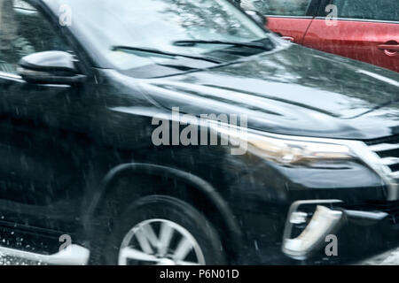 Il traffico di auto in moto durante la pioggia. vista offuscata Foto Stock