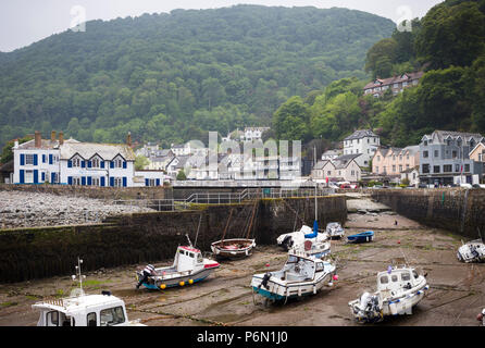 Il villaggio di Lynmouth, North Devon - vista del porto con la bassa marea con barche, case e hillside al di là. Foto Stock