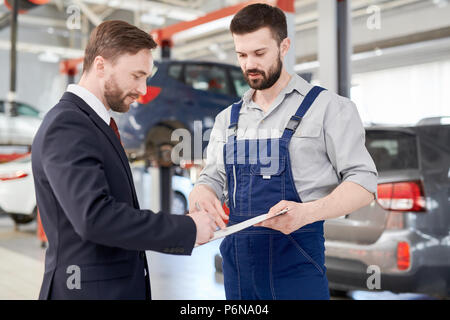 Imprenditore firma contratto in auto di servizio Foto Stock